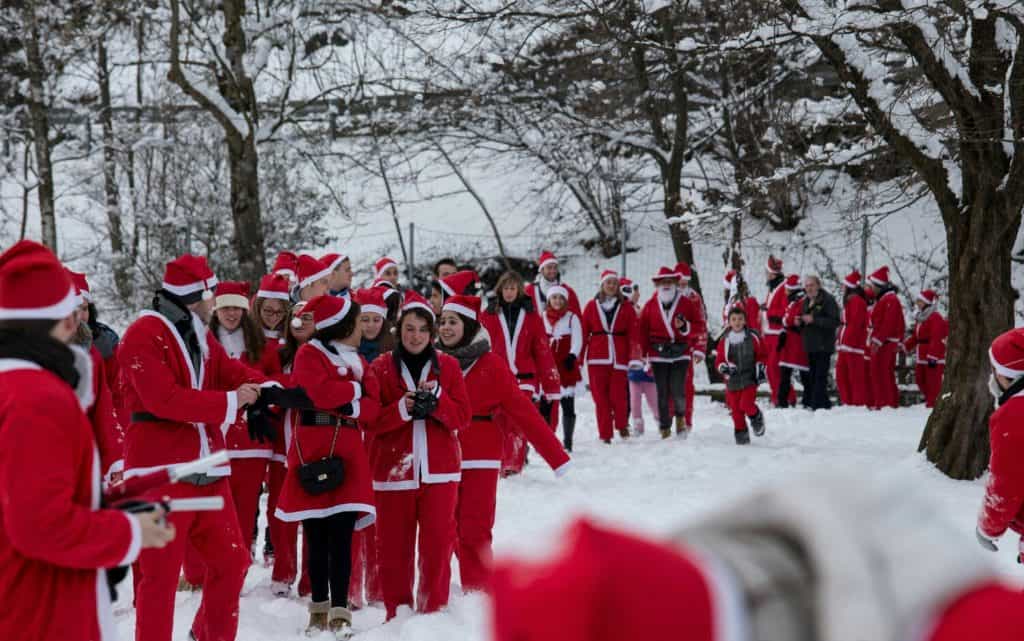 Babbi Natale camminano nella neve a Ledro