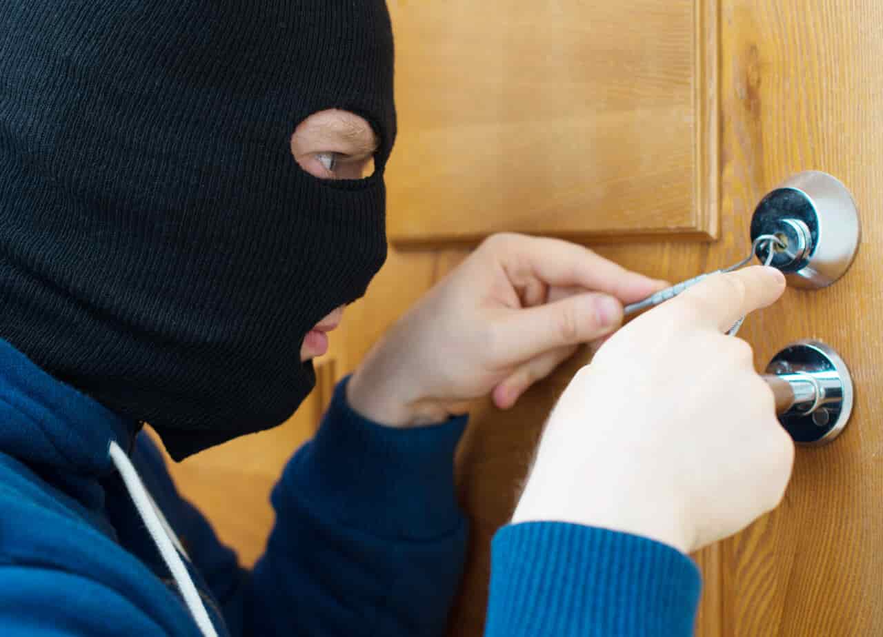 Thief opening door with lock picker.